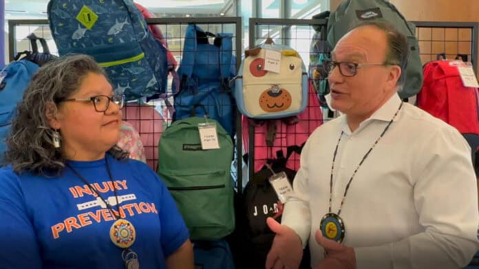Chief at HQ in front of the backpack display in remembrance of lost children due to car accidents.